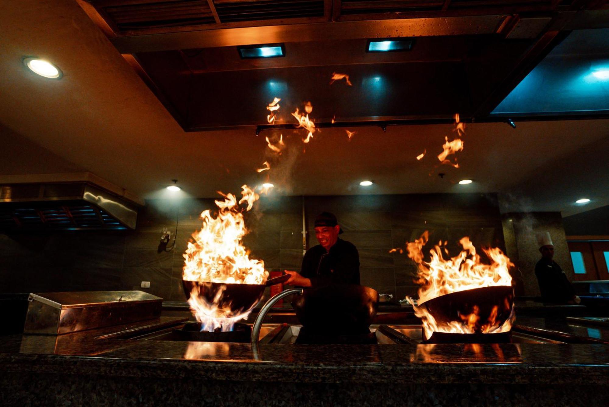 The V Luxury Resort Sahl Hasheesh الغردقة المظهر الخارجي الصورة A chef cooking with a wok