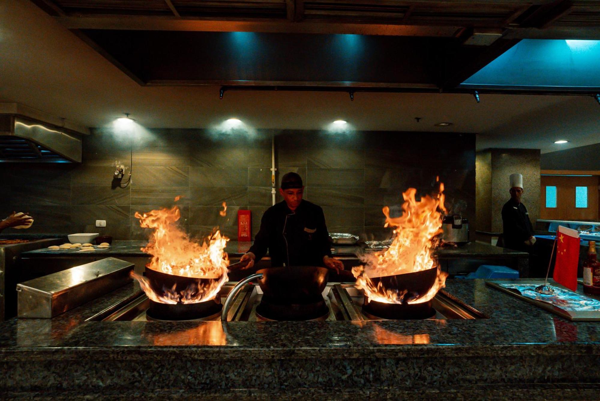 The V Luxury Resort Sahl Hasheesh الغردقة المظهر الخارجي الصورة A chef cooking with a wok